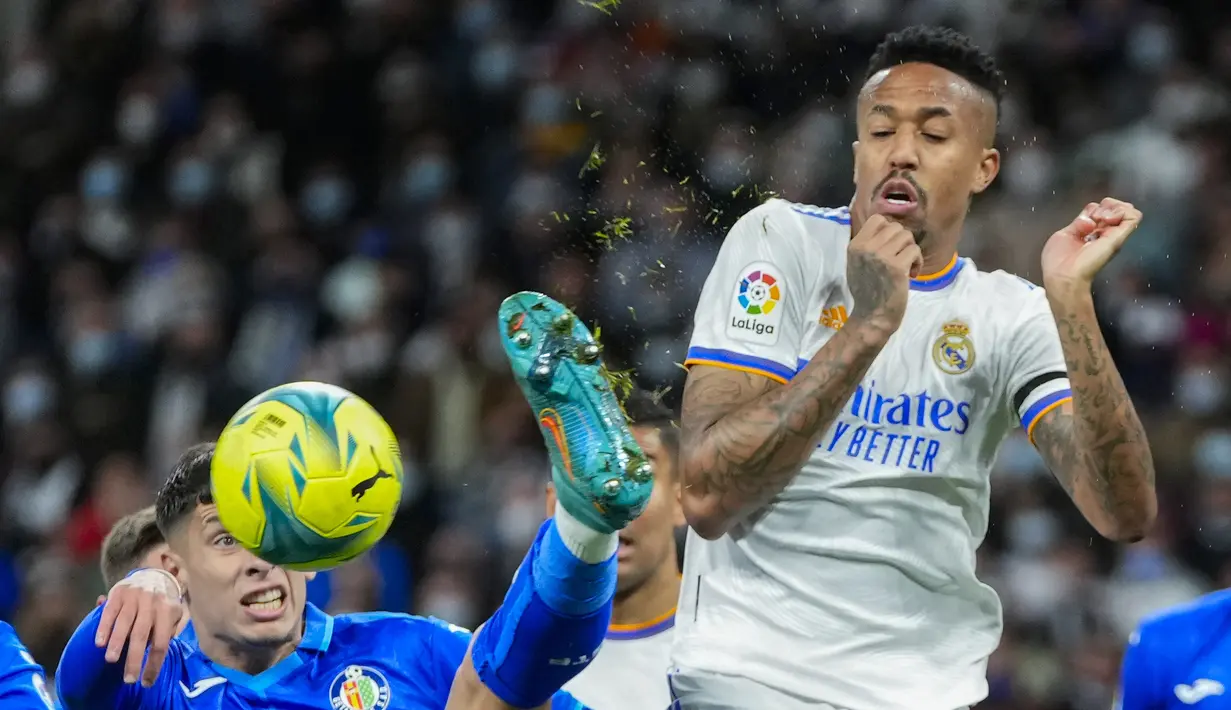 Bek Getafe, Mathias Olivera berebut bola dengan bek Real Madrid, Eder Militao pada pertandingan lanjutan La Liga Spanyol di stadion Santiago Bernabeu di Madrid, Minggu (10/4/2022). Real Madrid menang atas Getafe 2-0. (AP Photo/Manu Fernandez)