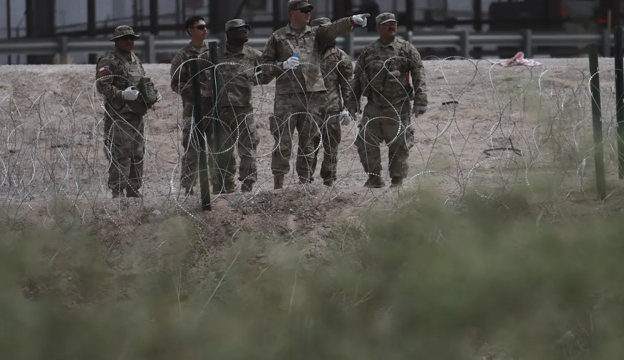 Anggota Garda Nasional Texas memasang penghalang kawat berduri di perbatasan antara El Paso, Texas dan Ciudad Juárez, seperti yang terlihat dari Ciudad Juárez, Meksiko, Rabu (3/5/2023). (AP Photo/Christian Chavez)
