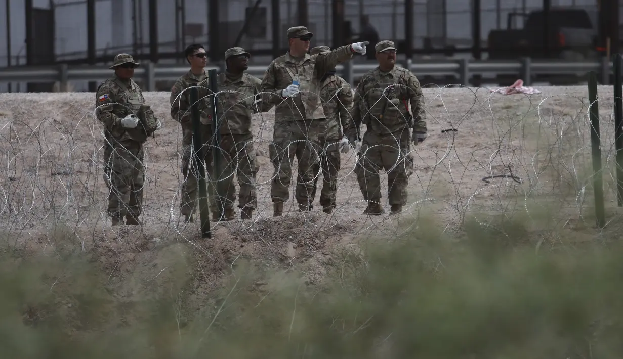 Anggota Garda Nasional Texas memasang penghalang kawat berduri di perbatasan antara El Paso, Texas dan Ciudad Juárez, seperti yang terlihat dari Ciudad Juárez, Meksiko, Rabu (3/5/2023). (AP Photo/Christian Chavez)