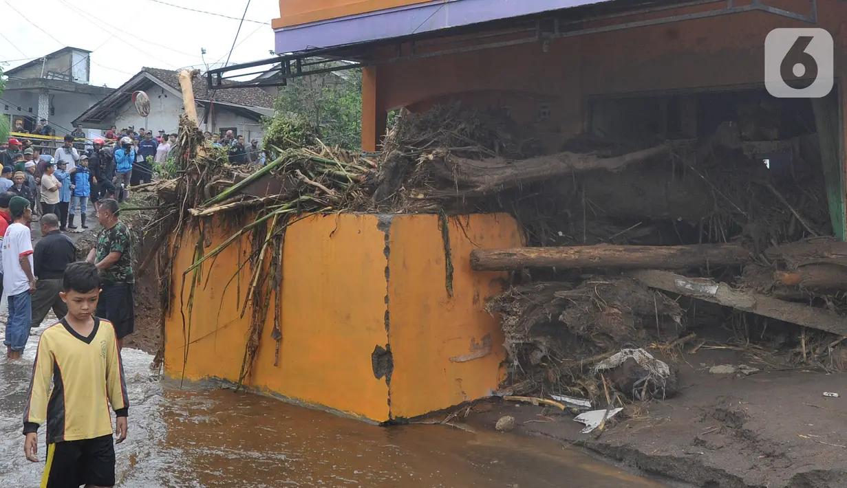 Seorang anak melintasi bangunan yang rusak usai banjir bandang melanda Kampung Cibuntu, Desa Pasawahan, Kecamatan Cicurug, Sukabumi, Jawa Barat, Selasa (22/9/2020). Data sementara puluhan bangunan rusak berat, 12 rumah hanyut, dan dua korban hilang masih dicari. (merdeka.com/Arie Basuki)