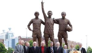 Patung George Best (kiri), Dennis Law (tengah), dan Bobby Charlton (kanan) berada di depan Old Trafford untuk mengingat kejayaan para legenda Manchester United itu. (AFP/Paul Ellis)