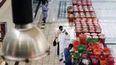 Orang-orang berbelanja selama pelelangan di pasar ikan di Kuwait City (8/8/2021). Pelelangan dibuka kembali di negara itu setelah enam bulan ditutup di tengah pandemi virus corona. (AFP/ Yasser Al-Zayyat)