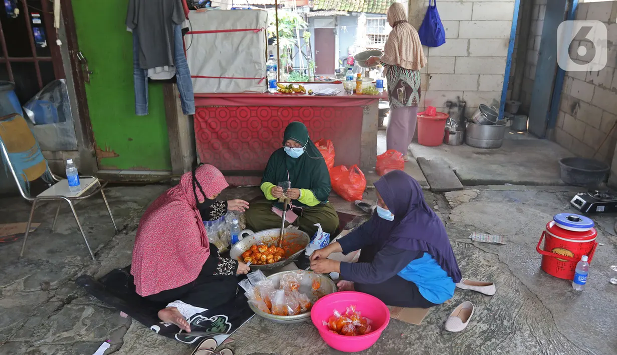 Warga mengemas bantuan bahan pokok untuk pasien positif Covid-19 di RT03/RW03, Kelurahan Cilangkap, Jakarta, Jumat (21/5/2021). Sebanyak 25 paket bahan pokok dari bantuan Dinas Sosial DKI Jakarta dan swadaya warga setempat diberikan kepada 25 Kepala Keluarga. (Liputan6.com/Herman Zakharia)
