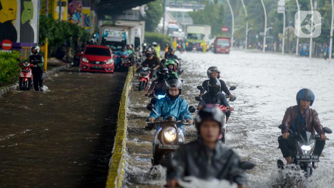 Pengendara sepeda motor menerjang banjir yang merendam Jalan Ahmad Yani, Jakarta, Sabtu (8/2/2020). Hujan yang mengguyur Jakarta sejak semalam membuat sejumlah ruas jalan terendam banjir. (merdeka.com/Imam Buhori)