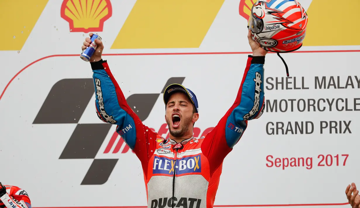 Pembalap Ducati Team, Andrea Dovizioso selebrasi di atas podium setelah berhasil memenangkan MotoGP Malaysia di sirkuit Sepang, Minggu (29/10). Dovizioso menyelesaikan balapan dengan catatan waktu 44 menit 51.497 detik. (AP/Vincent Thian)