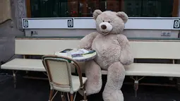 Sebuah boneka beruang raksasa terlihat di kafe Les Deux Magots yang ditutup di Paris, Prancis, pada 16 Desember 2020. Boneka beruang itu dipajang untuk menggantikan pengunjung saat restoran tutup selama penerapan jam malam guna menekan laju penyebaran COVID-19. (Xinhua/Gao Jing)