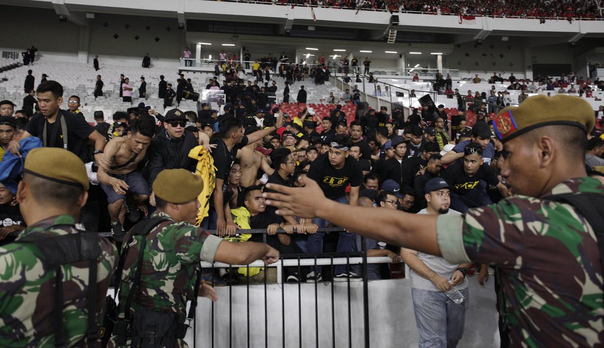 TNI mengevakuasi suporter Malaysia karena serangan dari suporter Timnas Indonesia saat laga Kualifikasi Piala Dunia 2022 di SUGBK, Jakarta, Kamis (5/9). (Bola.com/Vitalis Yogi Trisna)