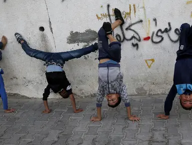 Anak laki-laki Palestina melakukan pemanasan saat mengikuti pelatihan tari di kamp pengungsi Al-Nusairat, Jalur Gaza tengah (5/11/2019). Pada 2012, Ahmed dan teman-temannya mendirikan sekolah tari di kamp pengungsi Nuseirat. (AP Photo/Hatem Moussa)