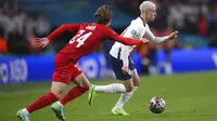 Gelandang Inggris, Phil Foden membawa bola dari kawalan pemain Denmark, Mathias Jensen pada pertandingan semifinal Euro 2020 di Stadion Wembley, London, Kamis (8/7/2021). Perjalanan terjauh Inggris di pentas Eropa sebelumnya adalah semifinal. (Laurence Griffiths/Pool Photo via AP)