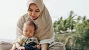 Saat bermain di pantai bersama sang buah hati saja Aryani tampil dengan penuh kesederhanaan. Ia memakai hijab langsung pakai yang dipadukan dengan baju santainya. (Instagram/aryanifitriana24)