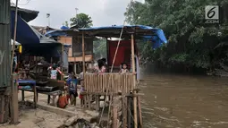 Aktivitas warga di bantaran Kali Ciliwung, Bukit Duri, Jakarta, Kamis (12/4). Warga sekitar mengaku betah tinggal di bantaran kali meski rela kebanjiran di kala musim penghujan. (Merdeka.com/Iqbal Nugroho)