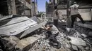 Pakar bahan peledak Hamas mencari proyektil yang tidak meledak dari reruntuhan bangunan setelah konflik Mei 2021 dengan Israel di Kota Gaza, Sabtu (5/6/2021). Perang 11 hari antara Hamas dan Israel menewaskan 254 orang Palestina dan 12 orang Israel. (MAHMUD HAMS/AFP)