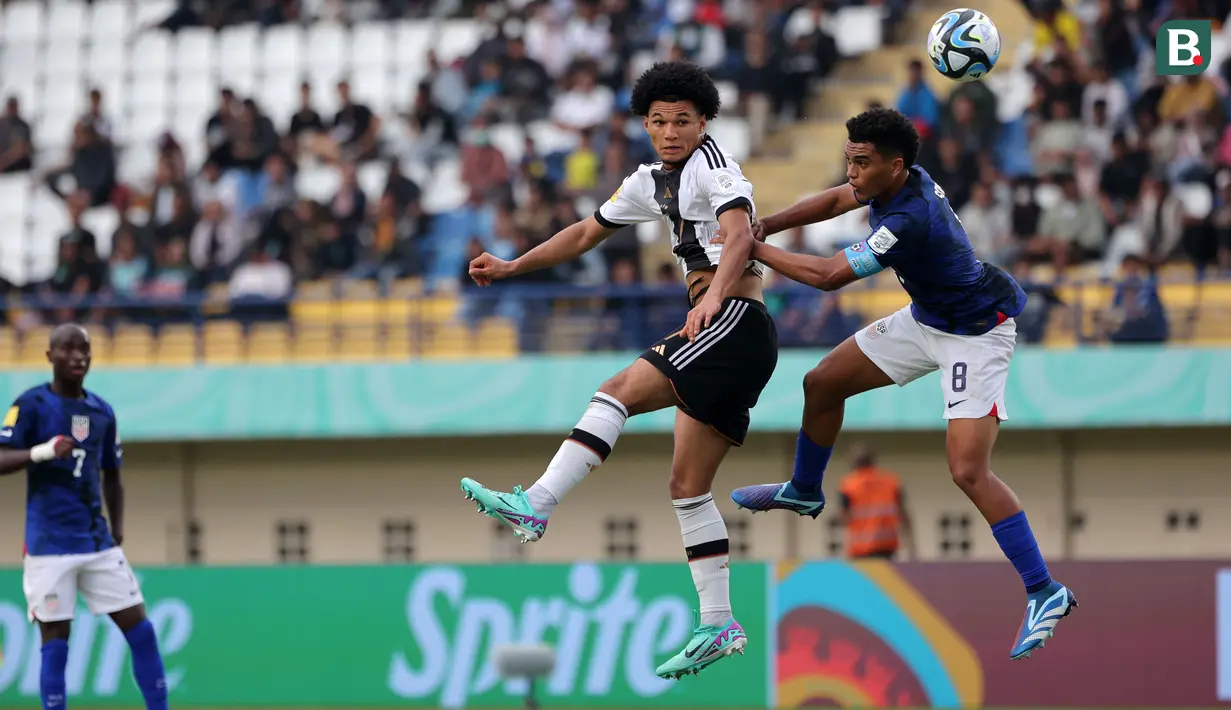Pemain Timnas Jerman U-17, Eric Da Silva Moreira (kiri) berduel udara dengan pemain Timnas Amerika Serikat U-17, Pedro Soma pada laga 16 besar Piala Dunia U-17 2023 yang berlangsung di Si Jalak Harupat, Bandung, Selasa (21/11/2023). (Bola.com/Ikhwan Yanuar)
