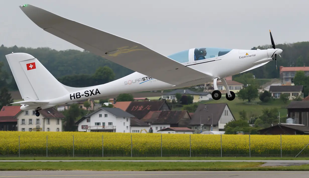 Pilot Damian Hischier menerbangkan pesawat SolarStratos saat lepas landas saat penerbangan pertama di Payerne, Swiss (5/5). Pesawat ini hanya dapat dinaiki dua penumpang. (AFP Photo/Fabrice Coffrini)