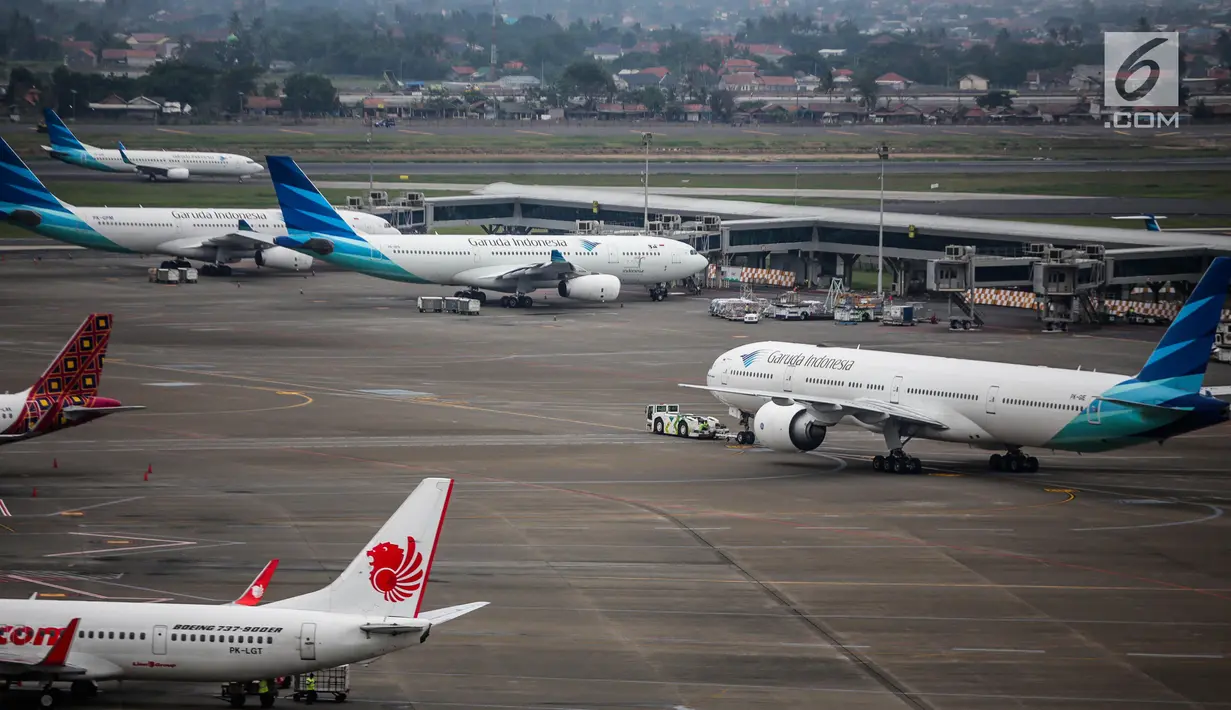 <p>Pesawat maskapai Garuda Indonesia terparkir di areal Bandara Soekarno Hatta, Tangerang, Banten, Kamis (16/5/2019). Pemerintah akhirnya menurunkan tarif batas atas (TBA) tiket pesawat atau angkutan udara sebesar 12-16 persen yang berlaku mulai Kamis hari ini. (Liputan6.com/Faizal Fanani)</p>