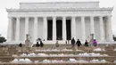 Pengunjung menaiki tangga Lincoln Memorial di Washington yang tertutup salju, Selasa (14/3). Badai salju menerjang kawasan Amerika Serikat timur laut, dari West Virginia hingga Maine, menyebabkan hujan salju lebat di sejumlah tempat. (Tasos Katopodis/AFP)