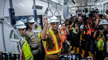 Gubernur DKI Jakarta Anies Baswedan saat mencoba Moda Raya Terpadu (MRT) dari Stasiun Bundaran HI-Lebak Bulus, Jakarta, Senin (10/12). Anies terlihat banyak tersenyum selama perjalanan. (Liputan6.com/Faizal Fanani)