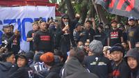 Tokoh Aremania, Anto Baret (memegang mikrofon) bersama rekan-rekannya saat aksi turun ke jalan didepan Kejari Kota Malang, Senin (31/10/2022). (Bola.com/Iwan Setiawan)