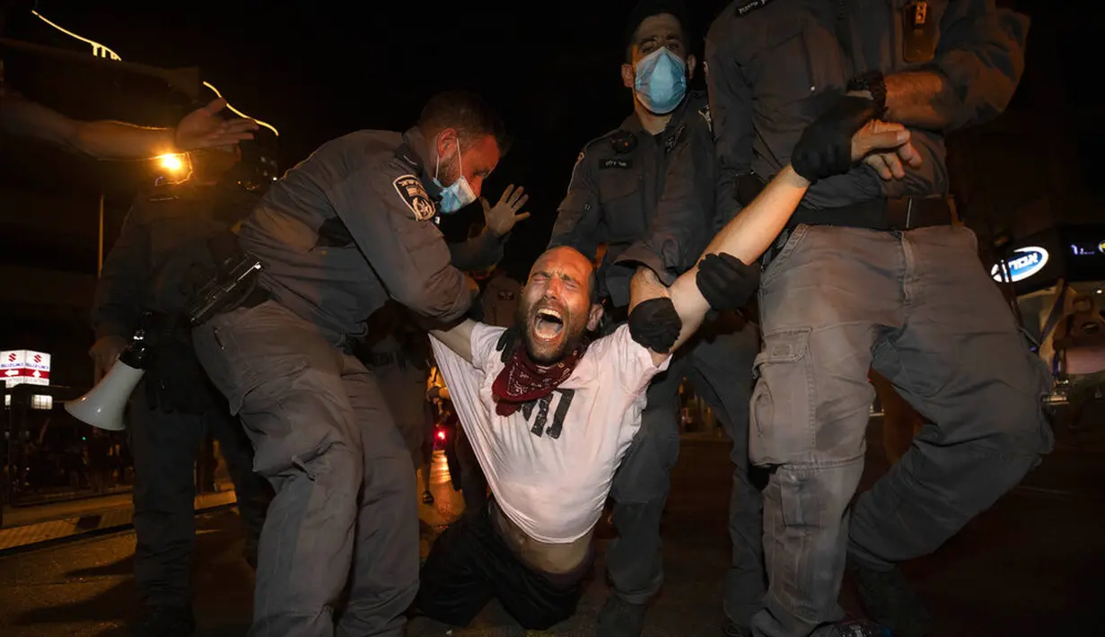 Polisi menahan seorang pengunjuk rasa selama demonstrasi menentang tindakan lockdown di Tel Aviv, Israel, Kamis (1/10/2020). Pengunjuk rasa meyakini lockdown ditujukan untuk mengekang protes terhadap Perdana Menteri Israel Benjamin Netanyahu. (AP Photo/Sebastian Scheiner)