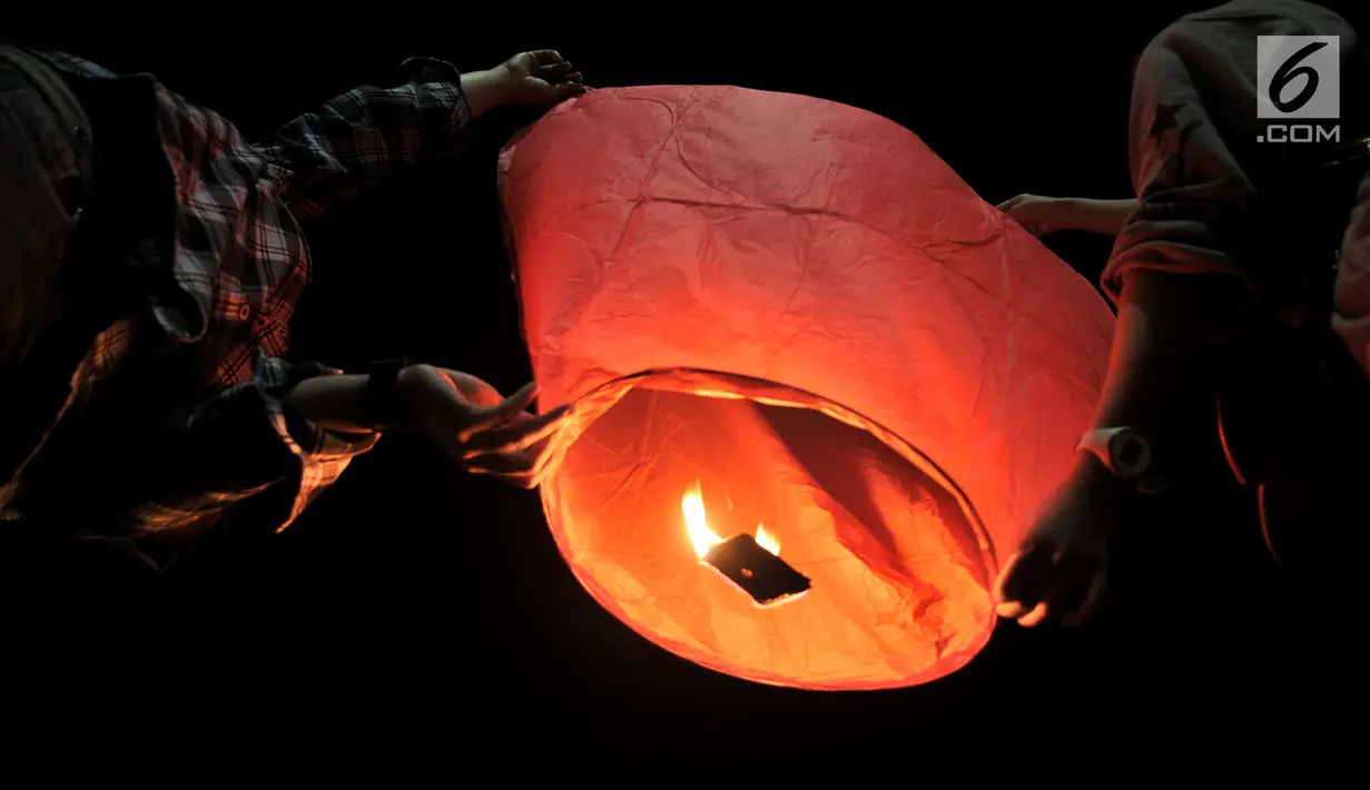 Pengunjung menerbangkan lampion saat perayaan Tahun Baru Imlek di Pantai Lagoon, Ancol, Jakarta, Selasa (5/2) malam. Sebanyak 500 lampion diterbangkan oleh pengunjung dalam  rangka menutup Festival Imlek di Ancol. (Merdeka.com/Iqbal S Nugroho)