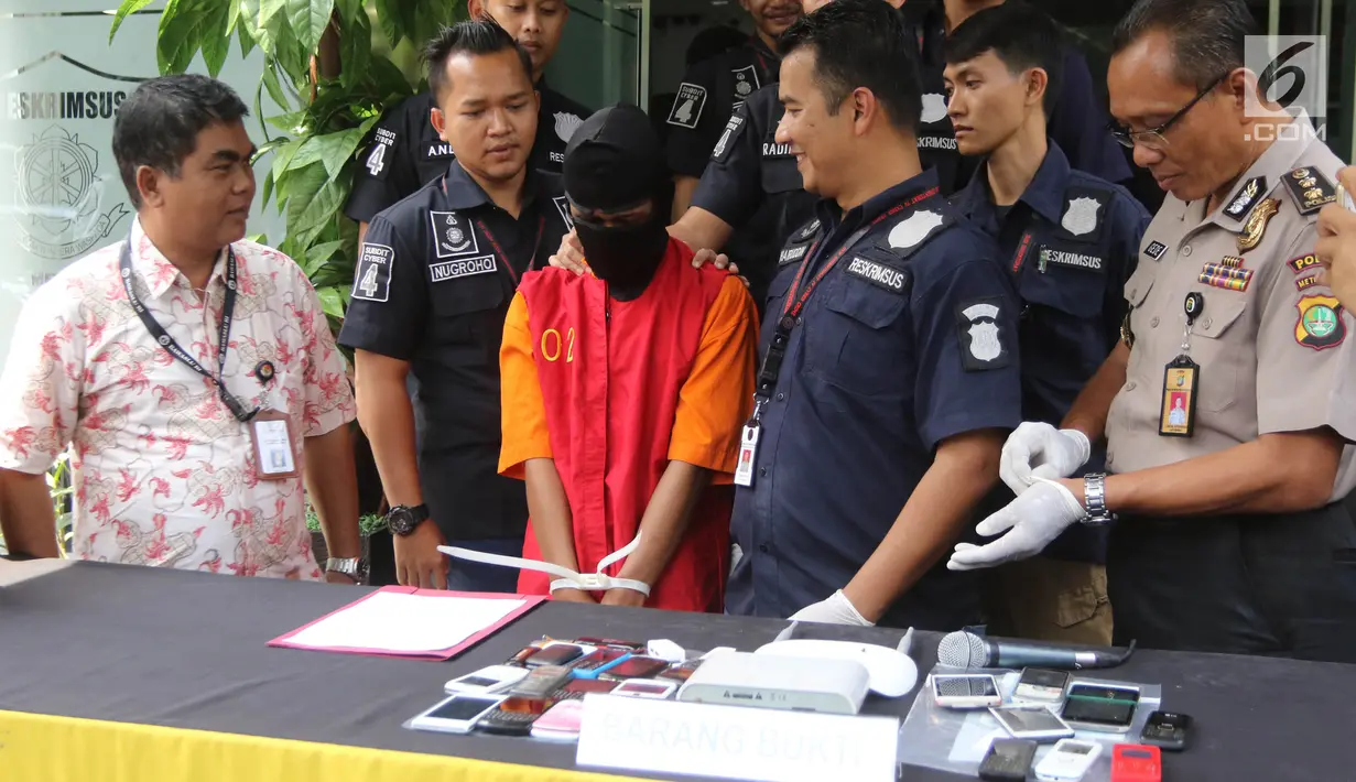 Petugas menghadirkan tersangka kasus penipuan beserta barang bukti saat rilis di Reskrimum Polda Metro Jaya, Jakarta, Kamis (22/3). Polisi berhasil menangkap AZ pelaku penipuan terhadap staf Bawaslu DKI Jakarta. (Liputan6.com/Arya Manggala)