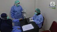 Petugas medis (kiri) mengukur tinggi badan seorang tenaga kesehatan (kiri) saat skrining kesehatan dalam simulasi pemberian vaksin COVID-19 di RSIA Tambak, Jakarta, Rabu (13/10/2021). Vaksinasi COVID-19 akan dilakukan oleh Pemprov DKI Jakarta pada 15 Januari 2021. (Liputan6.com/Herman Zakharia)