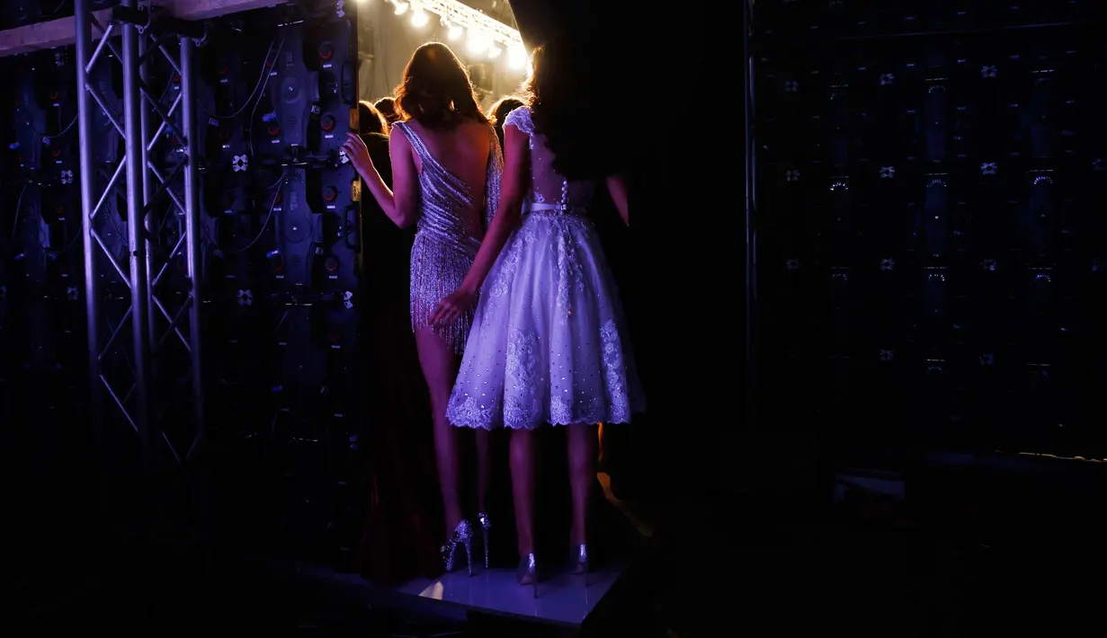 Dua model melihat penampilan rekan-rekanny saat berjalan di atas catwalk selama Beirut Fashion Week di Beirut, Lebanon (3/11). (AP Photo / Hassan Ammar)