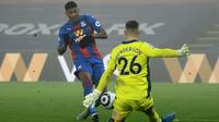 Bek Crystal Palace, Patrick van Aanholt melepakan tendangan yang berhasil dipatahkan kiper Manchester United, Dean Henderson dalam laga lanjutan Liga Inggris 2020/21 pekan ke-27 di Selhurst Park, Rabu (3/3/202). Crystal Palace bermain imbang 0-0 dengan Manchester United. (AFP/Mike Hewitt/Pool)