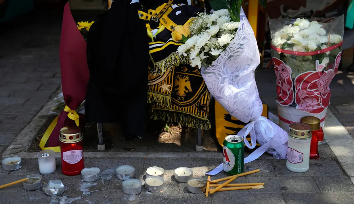 Lilin dan bunga tergeletak pada lokasi di mana seorang suporter sepak bola Yunani meninggal dalam bentrokan antara pendukung AEK Athens dan Dinamo Zagreb di pinggiran Nea Philadelphia, Athena, Yunani, Selasa (8/8/2023). (AP Photo/Thanassis Stavrakis)