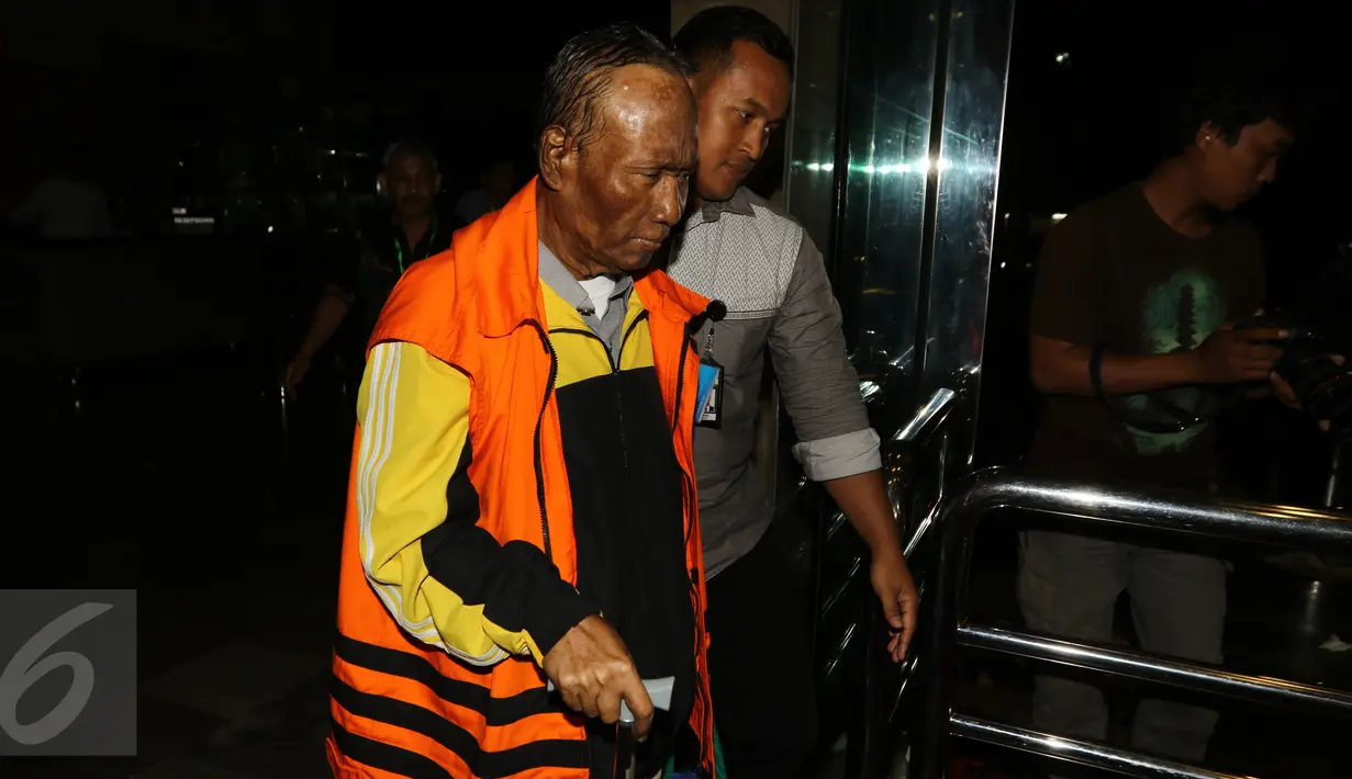 Sugiharto didampingi petugas berjalan keluar usai diperiksa KPK, Jakarta, Selasa (25/10). Tersangka korupsi paket penerapan pengadaan KTP elektronik atau e-KTP itu kini hanya menggunakan tongkat untuk membantunya berjalan. (Liputan6.com/Helmi Afandi)