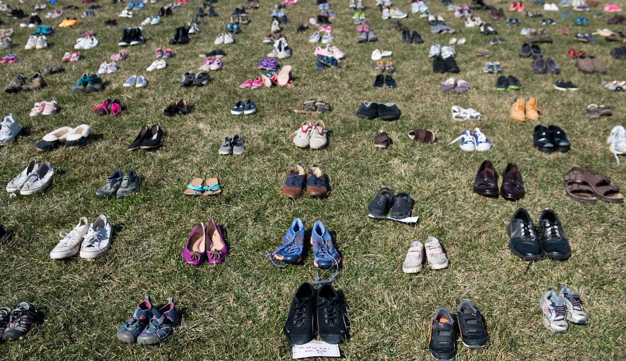 Ribuan sepatu menutupi halaman rumput di depan Gedung Capitol, Washington DC, Selasa (13/3). Sekitar 7000 ribu sepatu hasil sumbangan warga dan aktivis ini melambangkan korban penembakan di bawah usia 18 tahun. (AFP PHOTO/SAUL)