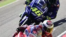 Pembalap Ducati Team, Jorge Lorenzo diikuti pembalap Movistar Yamaha, Valentino Rossi beradu kecepatan pada balapan MotoGP Aragon di Spanyol, Minggu (24/9). Juara dunia tujuh kali kelas MotoGP itu memulai balapan dari posisi tiga. (JOSE JORDAN/AFP)