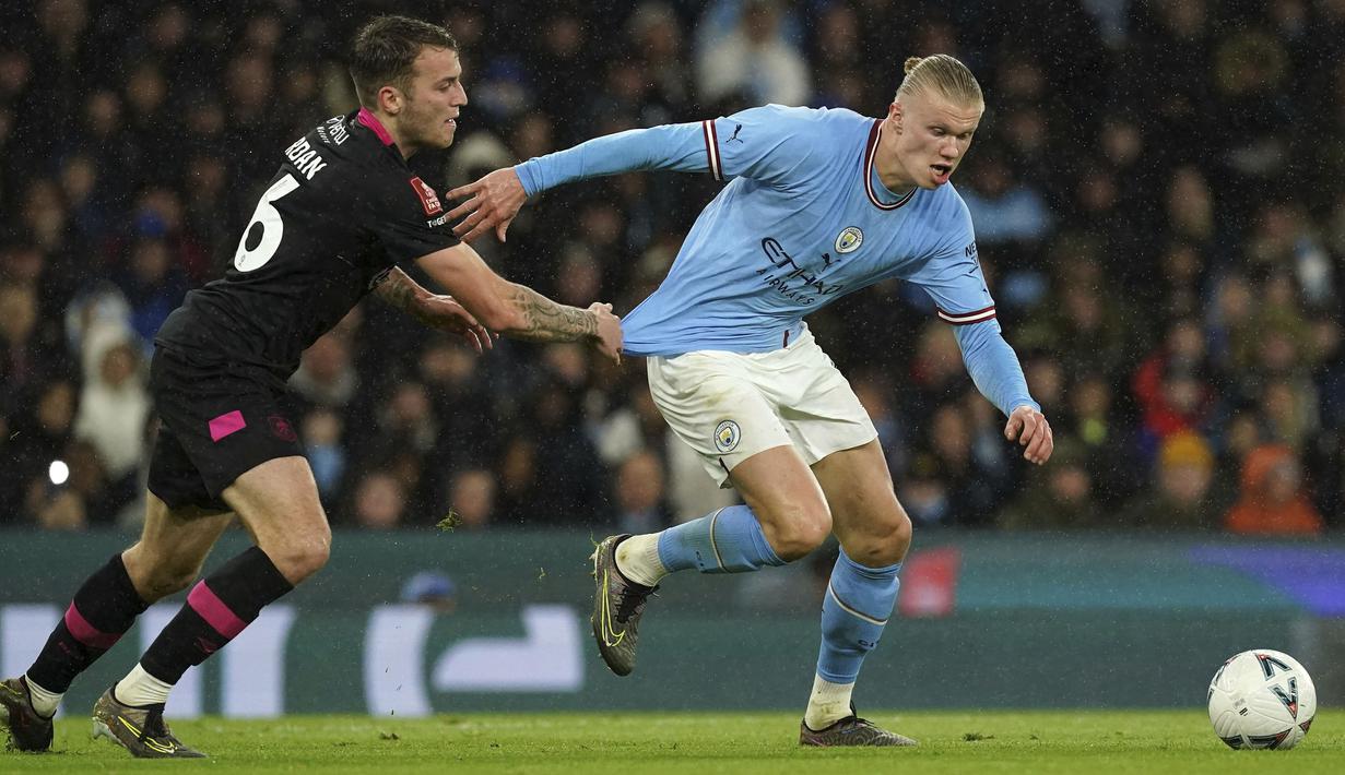 Pemain Manchester City, Erling Haaland (kanan) berebut bola dengan pemain Burnley, Jordan Beyer pada laga perempat final FA Cup 2022/2023 yang berlangsung di Etihad Stadium, Manchester, Minggu (19/03/2023) WIB. Haaland sukses mencetak hattrick untuk kemenangan 6-0 The Cityzens. (AP Photo/PA/Martin Rickett)