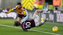 Pemain Aston Villa, Jack Grealish, terjatuh saat berebut bola dengan pemain Wolverhampton Wanderers, Joao Moutinho, pada laga Liga Inggris di Stadion Molineux, Minggu (13/12/2020). Aston Villa menang dengan skor 0-1. (Tim Keeton/Pool/AFP)
