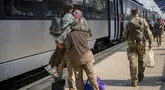 Seorang prajurit Ukraina memeluk istri dan putrinya di stasiun kereta api di Sloviansk, wilayah Donetsk, Ukraina pada Selasa, 12 September 2023. (AP Photo/Hanna Arhirova)