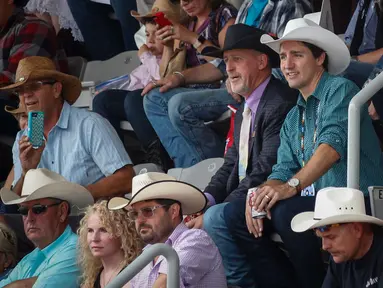 Perdana Menteri Kanada Justin Trudeau (tengah) menonton rodeo dalam acara Calgary Stampede di Calgary, Alberta, Kanada (15/7). Calgary Stampede adalah festival koboi yang digelar tiap tahun di Kanada. (Jeff McIntosh / The Canadian Press via AP)