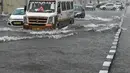 Sejumlah mobil melewati jalan yang tergenang air saat hujan lebat di New Delhi, India (1/9/2021). hujan lebat menyebabkan gangguan lalu lintas dan genangan air di daerah dataran rendah. (AFP/Prakash Singh)