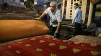 Pedagang memamerkan karpet tenun dagangannya kepada pengunjung pameran di Teheran, Iran, Kamis (29/8/2019). AS menghentikan impor karpet Iran setelah Presiden Donald Trump menjatuhkan sanksi terkait program nuklir negara tersebut. (AP Photo/Vahid Salemi)