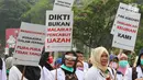 Sejumlah dokter muda berunjuk rasa di depan Istana Negara, Jakarta, Kamis (19/7). Mereka mengadukan isu terkait pungli Fakultas Kedokteran dan Kemenristek Dikti yang dinilai menghambat pengabdian Dokter Muda ke Masyarakat. (Liputan6.com/Johan Tallo)