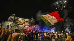 Suporter merayakan kemenangan Italia atas Inggris pada pertandingan final Euro 2020 di Roma, Italia, Senin (12/7/2021). Italia menjuarai Euro 2020 usai mengalahkan Inggris lewat drama adu penalti pada pertandingan final. (AP Photo/Alessandra Tarantino)