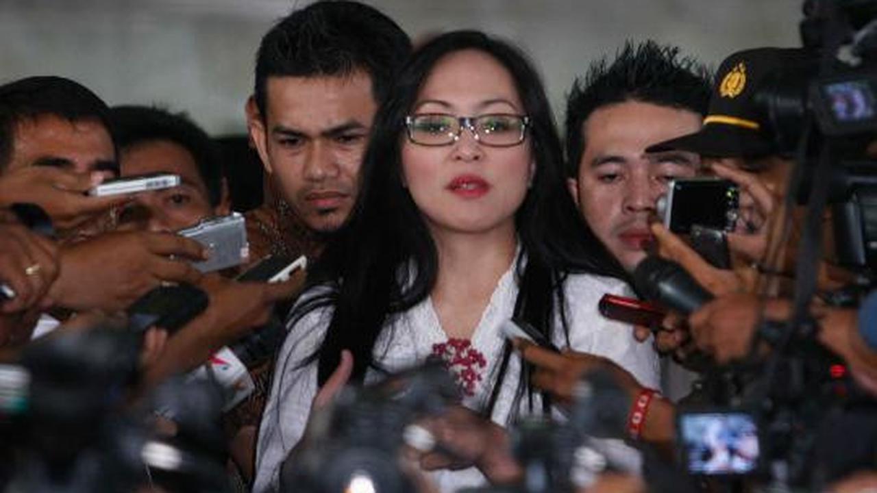 Angelina Sondakh tersenyum saat dikawal petugas keamanan KPK dan polis 