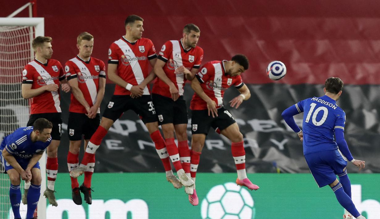 Gelandang Leicester City, James Maddison (kanan) melepaskan tendangan bebas ke gawang Southampton dalam laga lanjutan Liga Inggris 2020/2021 pekan ke-34 di St Mary's Stadium, Southampton, Jumat (30/4/2021). Leicester bermain imbang 1-1 dengan Southampton. (AFP/Kirsty Wigglesworth/Pool)