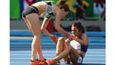 Pelari Nikki Hamblin dari Selandia Baru membantu pelari AS, Abbey D'Agostino, saat mengalami nyeri kaki setelah terjatuh pada lari 5000m putri Olimpiade Rio 2016 di Olympic Stadium, Rio de Janeiro, Brasil, (16/8/2016). (Reuters/Kai Pfaffenbach)