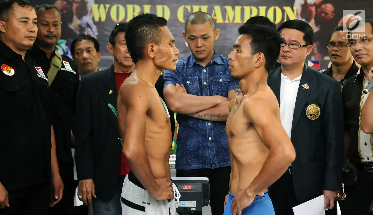Petinju Indonesia Tibo Monabesa (kiri depan) bertatapan dengan Arnold Garde (Filipina) usai melakukan timbang badan di GOR Cendrawasih, Jakarta, Jumat (19/5). Tibo akan mempertahankan gelar WBC Internasional Silver. (Liputan6.com/Helmi Fithriansyah)