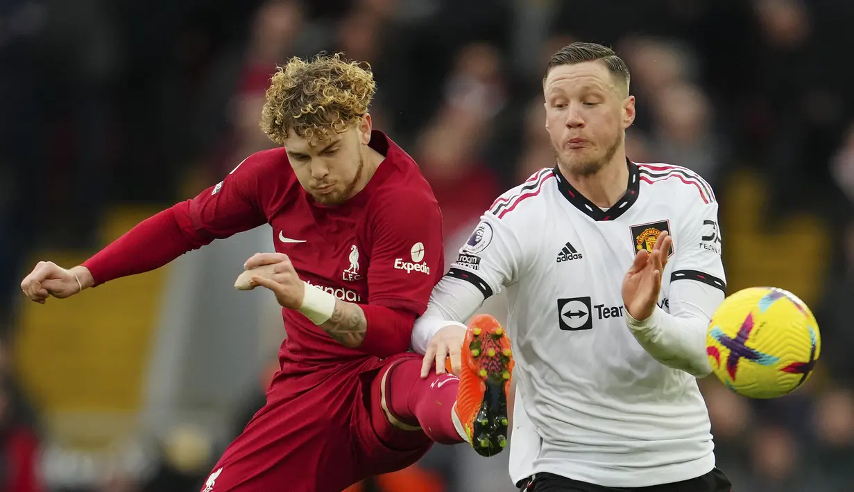 Penyerang Manchester United, Wout Weghorst berebut bola dengan pemain Liverpool, Harvey Elliott selama pertandingan lanjutan Liga Inggris di stadion Anfield, Inggris, Minggu (5/3/2023). Liverpool memenangkan pertandingan melawan Manchester United dengan skor telak 7-0. (AP Photo/Jon Super)