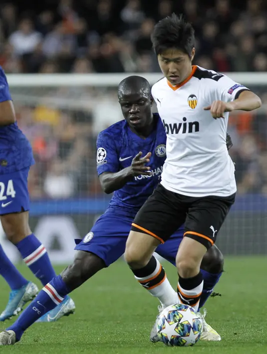 Gelandang Chelsea, N'Golo Kante berusaha merebut bola yang dibawa gelandang Valencia, Lee Kang-in pada pertandingan Grup H Liga Champions di  Mestalla stadium, Spanyol (27/11/2019). Chelsea bermain imbang 2-2 atas Valencia. (AP Photo/Alberto Saiz)