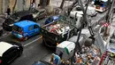 Sebuah truk yang dilengkapi dengan derek mengambil sampah di jalan setelah hujan lebat membubarkan sampah yang menumpuk karena pemogokan pemulung di Marseille, Prancis selatan,  Senin (4/10/2021). Wilayah Prancis selatan dalam siaga untuk hujan lebat dan banjir. (AFP Photo/Nicolas Tucat)