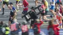 Seorang peserta mengenakan pakaian penyapu cerobong ikut memeriahkan ajang Berlin Maraton ke- 43 di Berlin (25/9/2016). (AFP/John Macdougall)