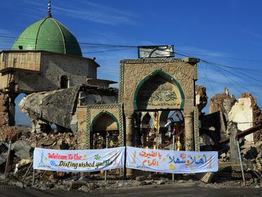 Masjid Agung al-Nuri dan sisa-sisa menara miring "Al-Hadba" yang dilanda perang di Kota Tua Mosul, 16 Desember 2018. Pemerintah Irak memulai pembangunan kembali masjid Abad ke-11 tersebut yang hancur dalam pertempuran  dengan ISIS. (Zaid AL-OBEIDI/AFP)