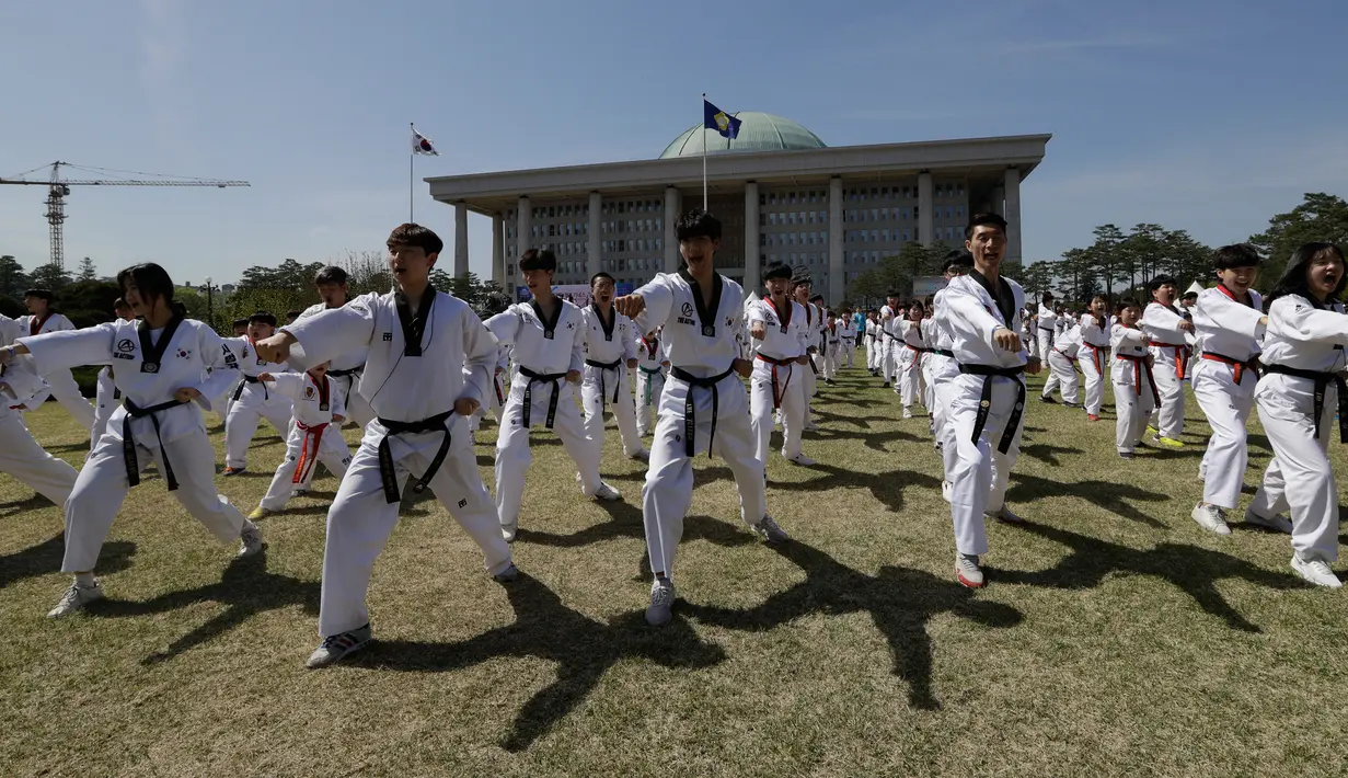 Peserta memperagakan seni bela diri taekwondo di depan Gedung Majelis Nasional Korea Selatan, Seoul, 21 April 2018. Ada 8.212 peserta yang memperagakan poomsae, pola gerakan pertahanan dan serangan, tanpa putus serta berkesinambungan. (AP/Lee Jin-man)
